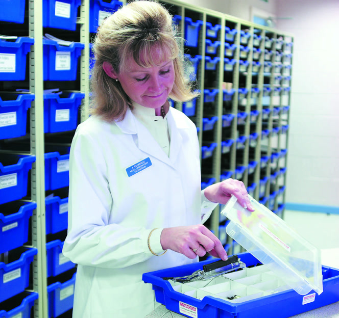 Professionnelle de santé utilisant des bacs de rangement médical.